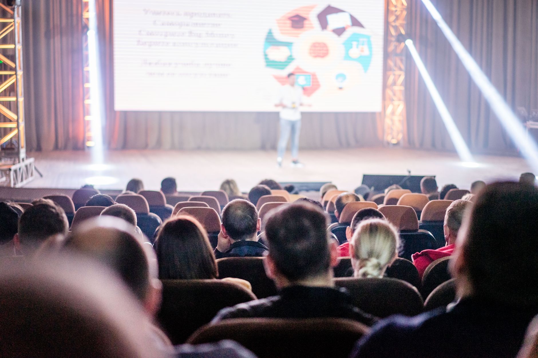 Delegates seated in an auditorium watching a speaker present at a conference