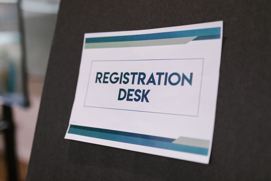 A printed Registration Desk sign at a conference venue
